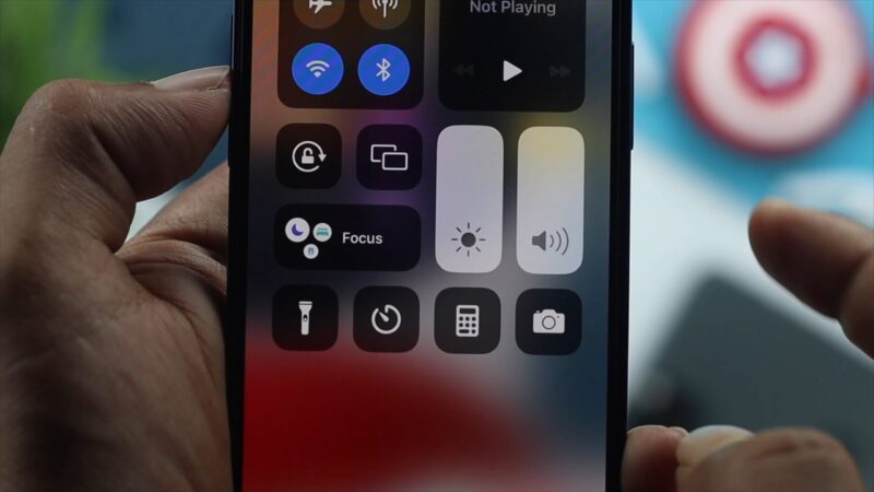 Close-up of an iPhone showing the Control Center with volume and brightness sliders visible