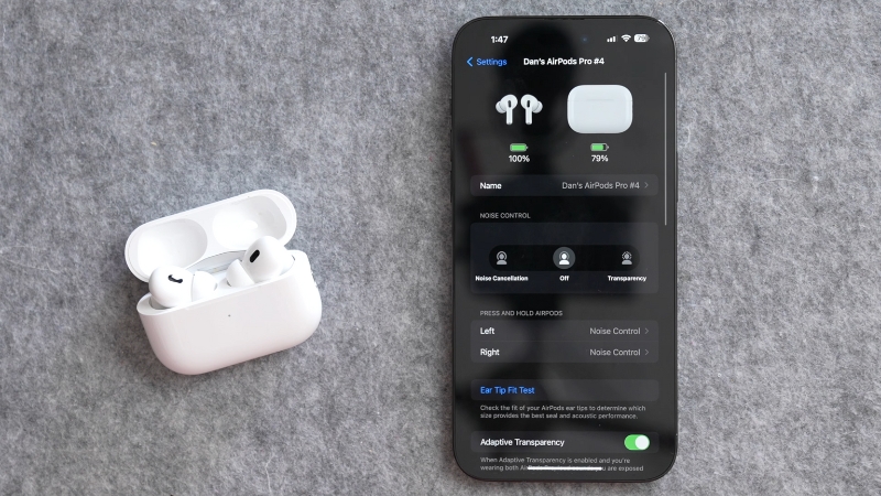 AirPods Case with Open Lid and iPhone Displaying AirPods Settings